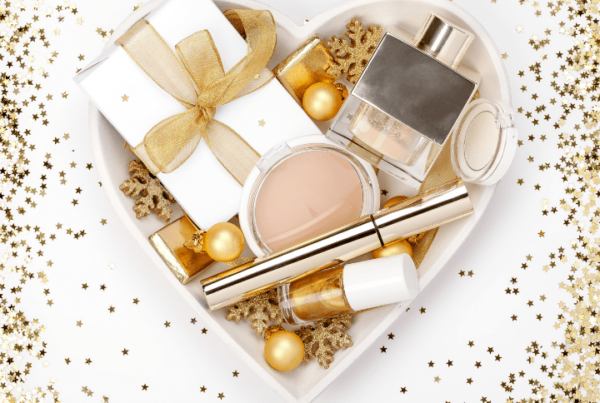 heart-shaped box, surrounded by gold glitter, filled with makeup and beauty presents