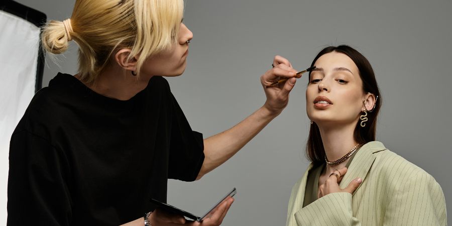 Professional makeup artist applying eyeshadow to a model, showcasing the client-focused questions makeup artists ask to achieve the perfect look.