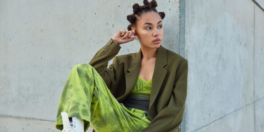 Fashion model with bantu knot hairstyle and bold outfit, highlighting the creative looks that inspire questions makeup artists often ask clients about style and preferences.