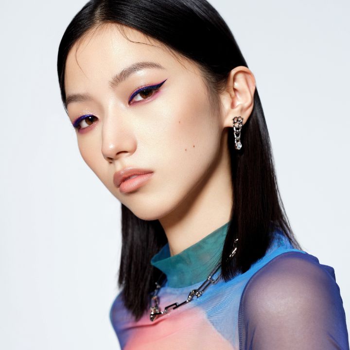 Woman confidently matching her makeup to her outfit with coordinated lipstick and fashion colors, demonstrating tips for balancing bold looks. Feature image for QC Makeup Academy blog article, 4 Rules for Matching Your Makeup to Your Outfit.