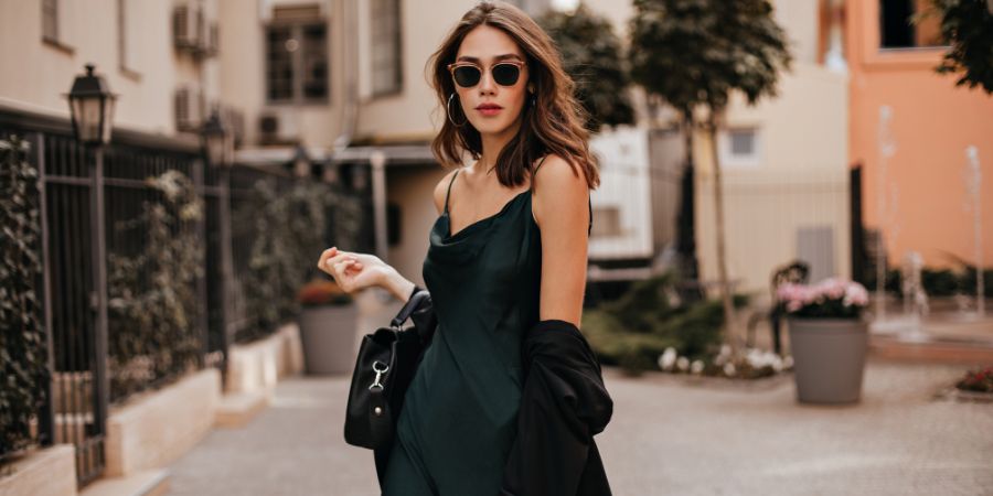 Stylish woman in a dark green dress with coordinated makeup, showing how matching your makeup to your outfit creates an elegant look.