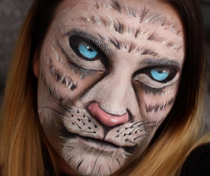 Cat makeup Halloween look featuring realistic feline face paint with blue eyes, whisker detailing, and shading for a striking Halloween makeup transformation.
