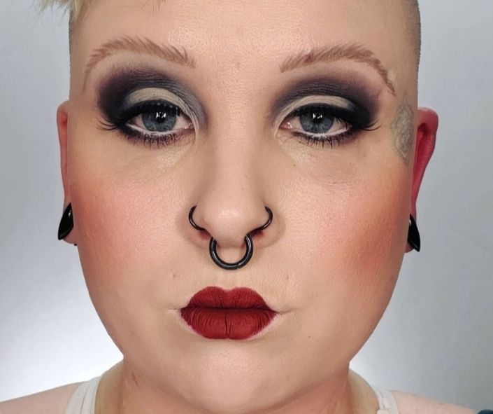 Easy Halloween makeup idea featuring bold black smoky eyeshadow, dramatic lashes, and matte red lipstick for a simple yet striking look.