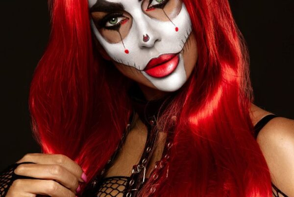Halloween makeup look featuring a scary clown design with bold eye makeup, red wig, and stitched face details – perfect for spooky Halloween makeup ideas.
