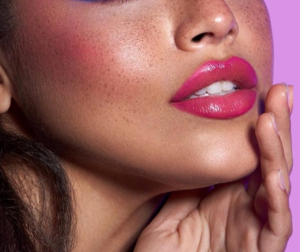 Close-up of vibrant pink lipstick and rosy blush highlighting a radiant complexion, perfect for a confident bold wedding makeup look.