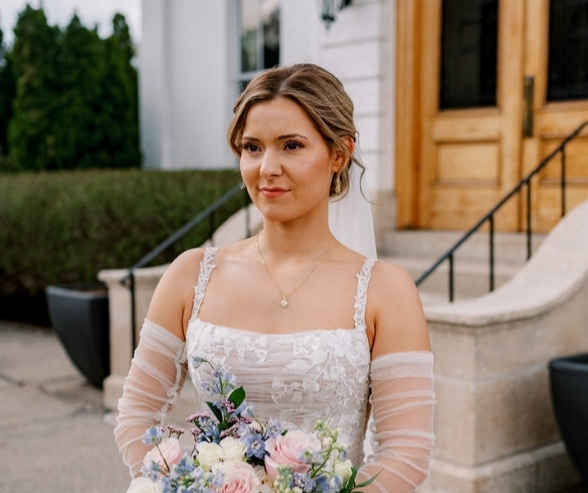 Elegant bride with natural glam makeup and soft pink tones holding a floral bouquet, showcasing timeless bride makeup ideas for a classic wedding look.