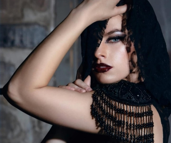 Model wearing dark red lipstick, smokey eye makeup, and black lace veil, showcasing dramatic artistic makeup looks with gothic elegance. Makeup by QC Makeup Academy student, Kate Loveland.