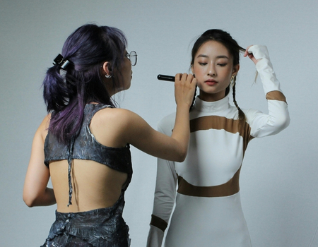 Behind-the-scenes makeup application during a fashion photoshoot