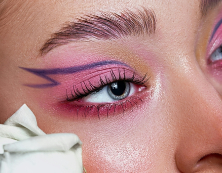 Pink eyeshadow makeup look with graphic eyeliner and soft shimmer skin