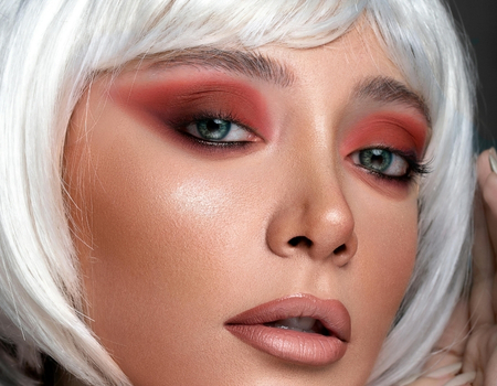 Editorial beauty portrait featuring dramatic red eyeshadow and porcelain skin