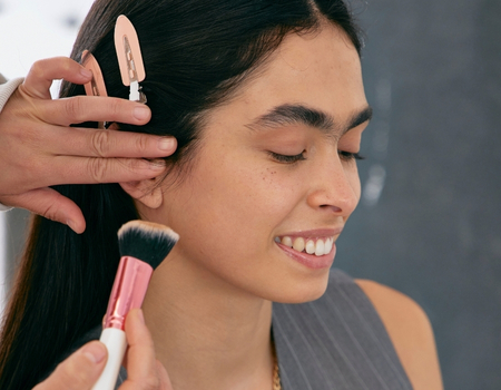 Makeup artist applying soft contour to define cheekbones during professional makeup application