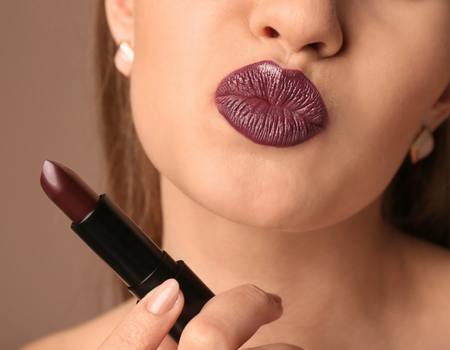 Close-up portrait featuring bold dark purple lip makeup