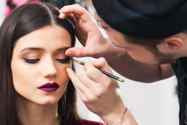 professional makeup artist applying editorial makeup look on client model