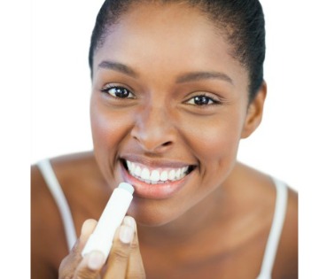 Woman applying lip balm for summer skin care routine