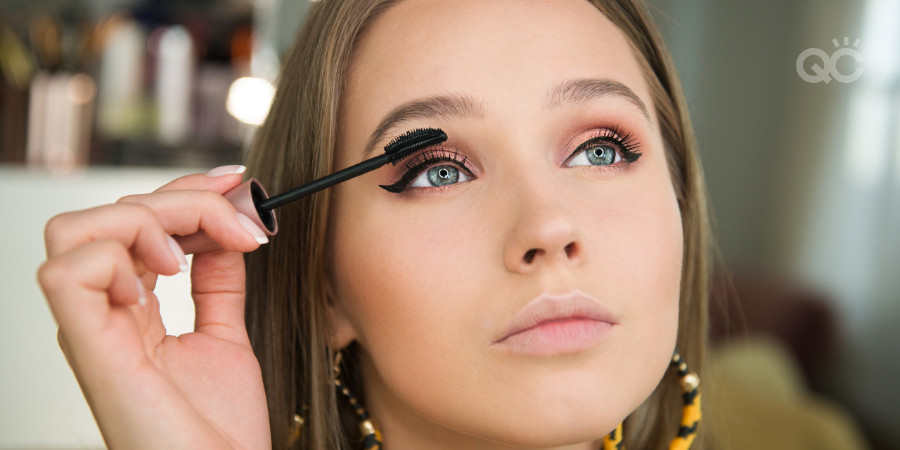 makeup artist applying mascara on herself