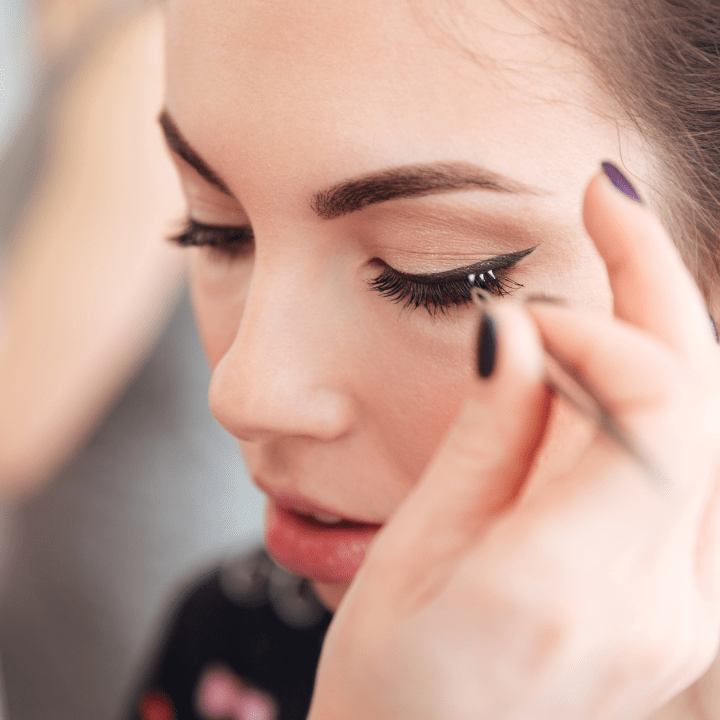 freelance makeup artist applying individual false lashes on client