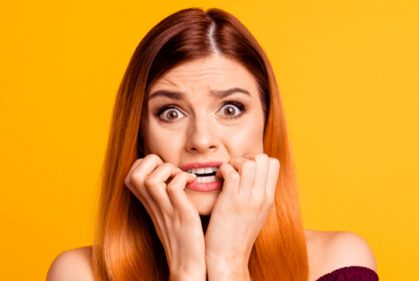 scared worried woman in front of yellow background