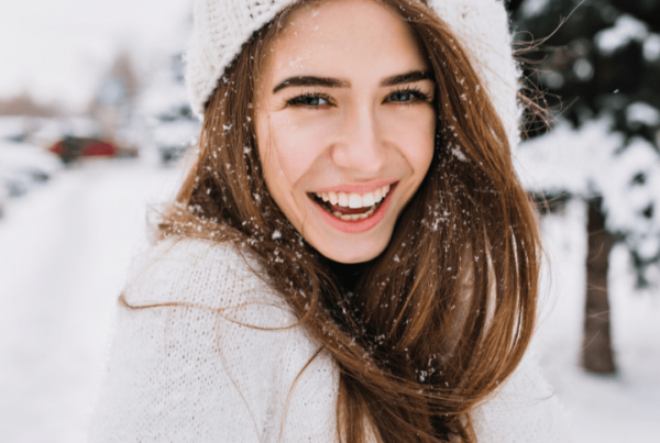 Spectacular long-haired woman laughing while posing on snow background. Outdoor close-up photo of caucasian female model with romantic smile chilling in park in winter day.