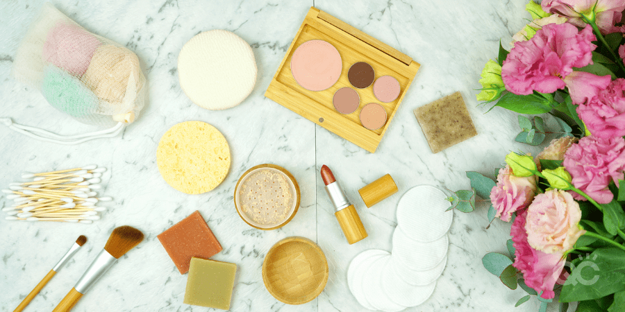 Zero-waste, plastic-free beauty and makeup flatlay overhead with coconut fiber, bamboo and reusable products.