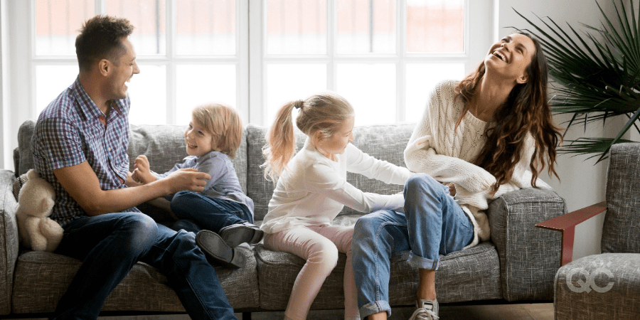 How to Become Makeup Artist as Stay-at-Home Mom Blog - Kids laughing with Parents on Sofa