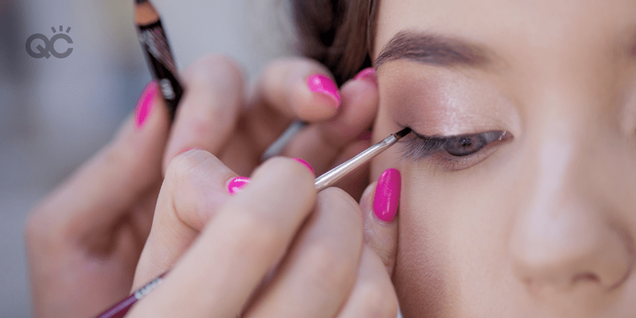 close up of makeup artist applying eye liner to client's eye