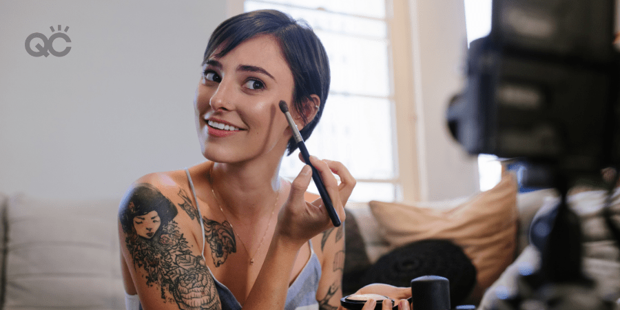 Woman applying makeup on camera