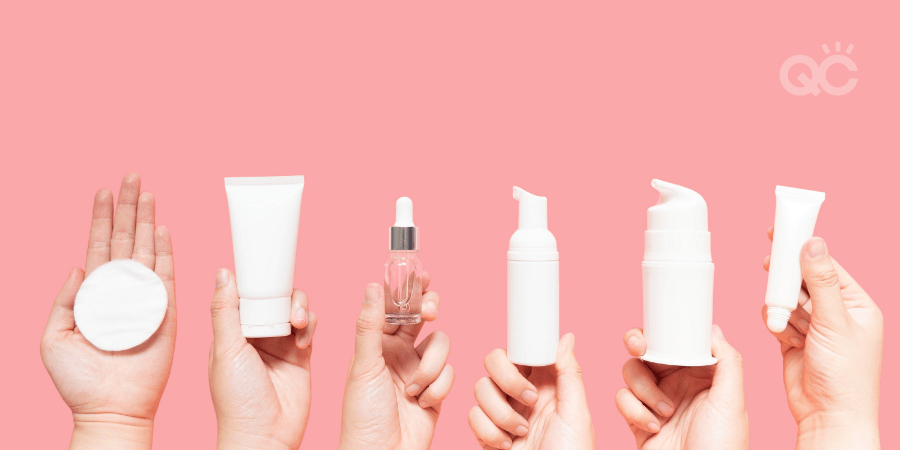 different hands holding up different skincare products in front of pink background