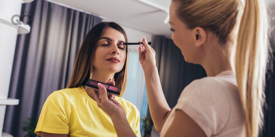 Makeup artist applying eyeshadow on model